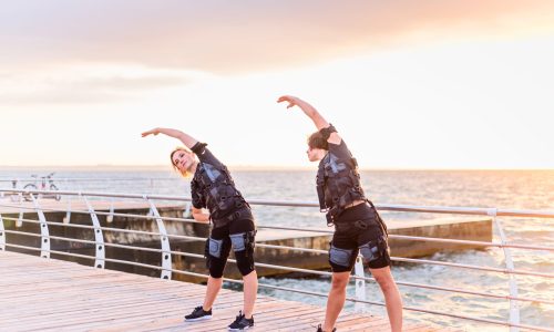 Women,With,Her,Instructor,Training,In,Ems,Trainer,On,Seaside